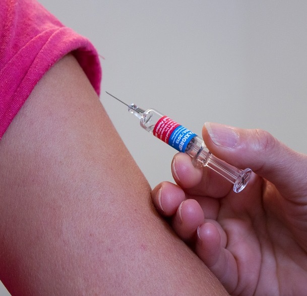 Needle injected on arm for flu vaccination services at GPs on Curzon.